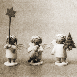 [Translate to Englisch (US):] Drei Margeritenengel. Sie halten jeweils einen Stern, ein Bäumchen und eine Puppe. Schwarz-Weiß-Aufnahme.