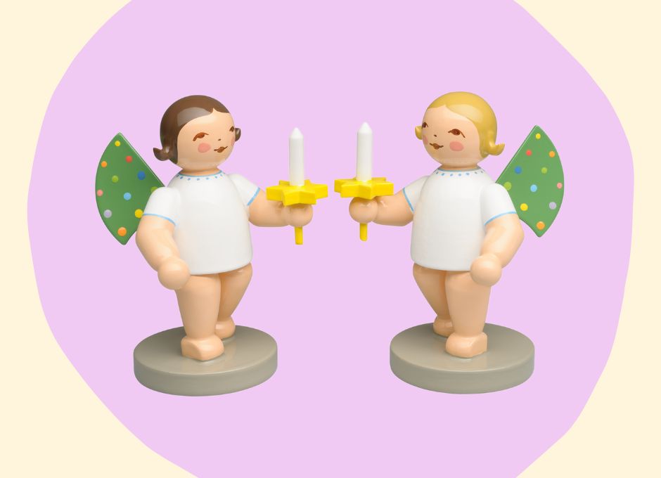 Two angel figurines on a purple background